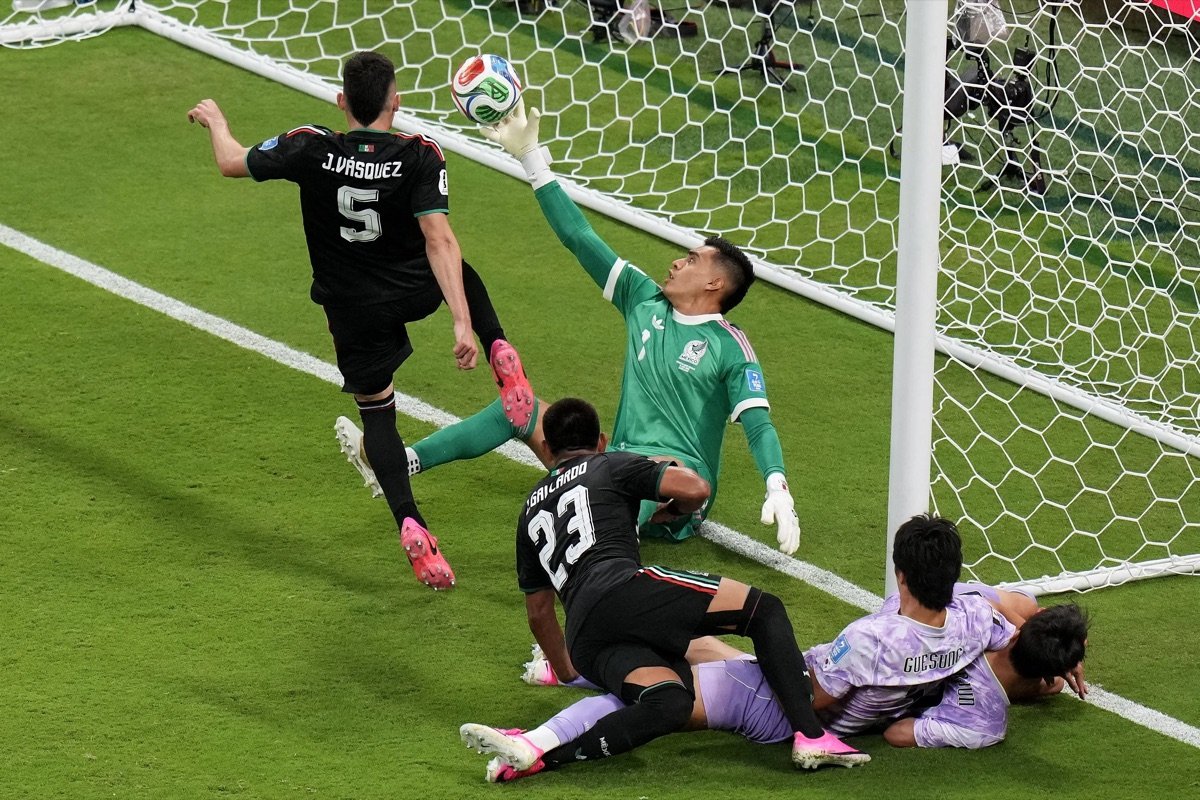 Mexico players challenge Korea Republic goalkeeper Kim Seung-gyu near the goal during their 2026 World Cup match
